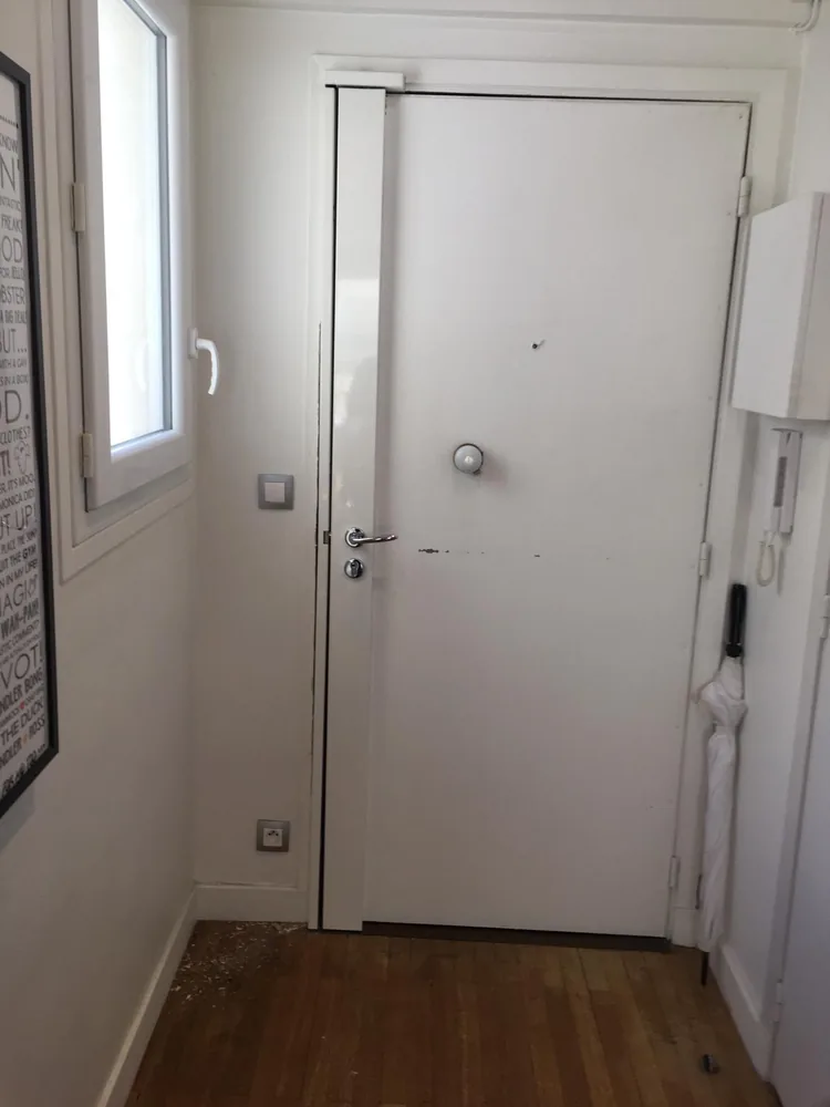 Porte palière blanche vue de l'intérieur, avec béquille chromée, cylindre et bouton de tirage