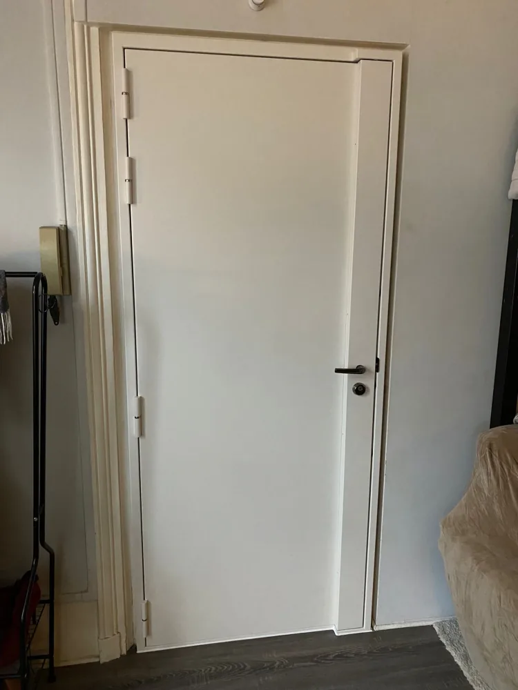 Porte blindée blanche avec carénage et cylindre noir remplacé après une perte de clés